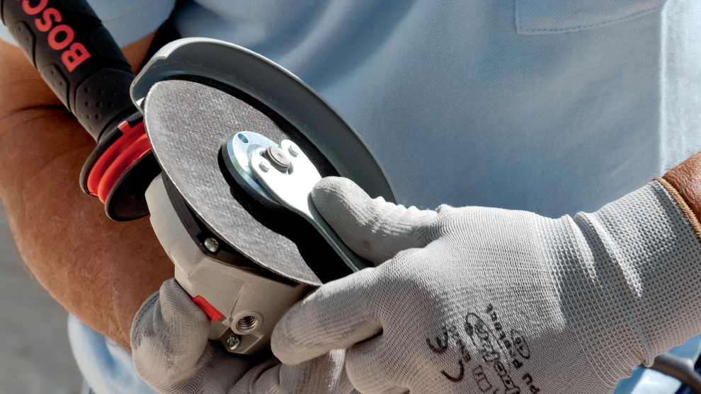 Seseorang memegang mesin penggiling Bosch Professional di tangannya.