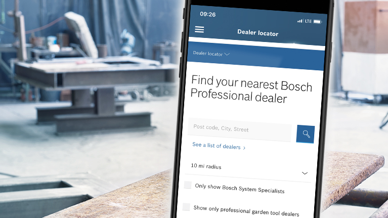 Sebuah smartphone menampilkan pencarian dealer Bosch Professional di sebuah bengkel.