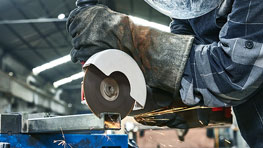 Seseorang memotong logam dengan cakram pemotong Bosch Professional.