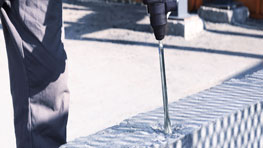 Seorang pengrajin menggunakan bor Bosch Professional pada batu bata.