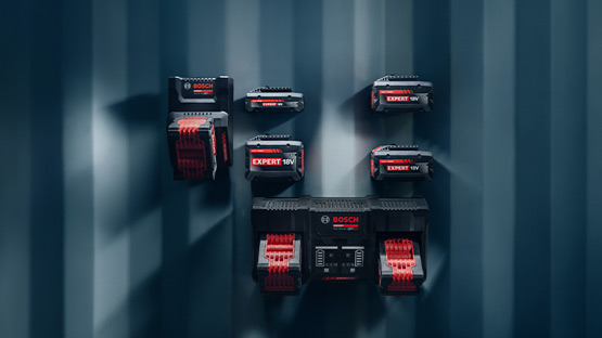 Enam baterai Bosch Professional berwarna merah-hitam dipasang di dinding yang terstruktur.
